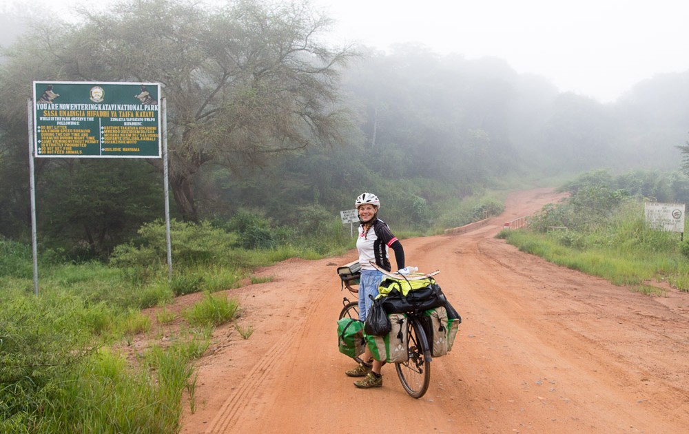 London to Cape Town Cyclists pose by the entrance sign of the  Katavi National Park in Uganda as they 